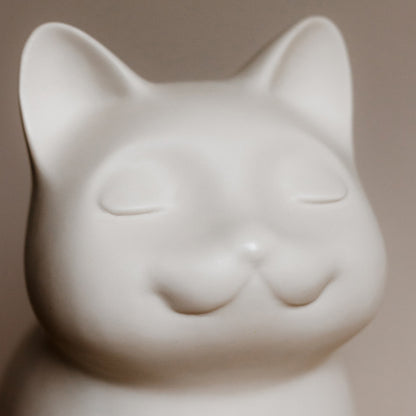 White ceramic cat urn figurine close up with eyes, ears. Features personalized cat urn for ashes, custom cat cremation urn, cat-shaped urn, sleeping cat statue urn, angel cat urn, and pet urns for cats including engravable and personalized options.