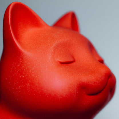 Close-up of a red ceramic cat urn on a gray background. Features personalized cat urn for ashes, custom cat cremation urn, cat-shaped urn, sleeping cat statue urn, and pet urns for cats with engravable and personalized options.
