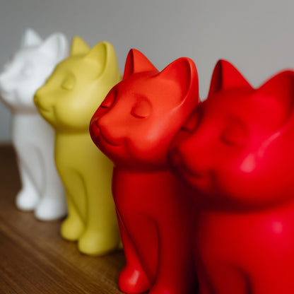 Four colorful cat-shaped cremation urns on a wooden surface with a neutral background. Features personalized cat urns for ashes, custom cat cremation urns, cat-shaped urns, sleeping cat statue urns, and pet urns for cats with engravable and personalized options.